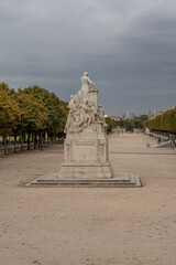 Paris, France - 09 16 2021: Tuileries garden. View of sculpture of Jules ferry in the park and La Defense buildings behind