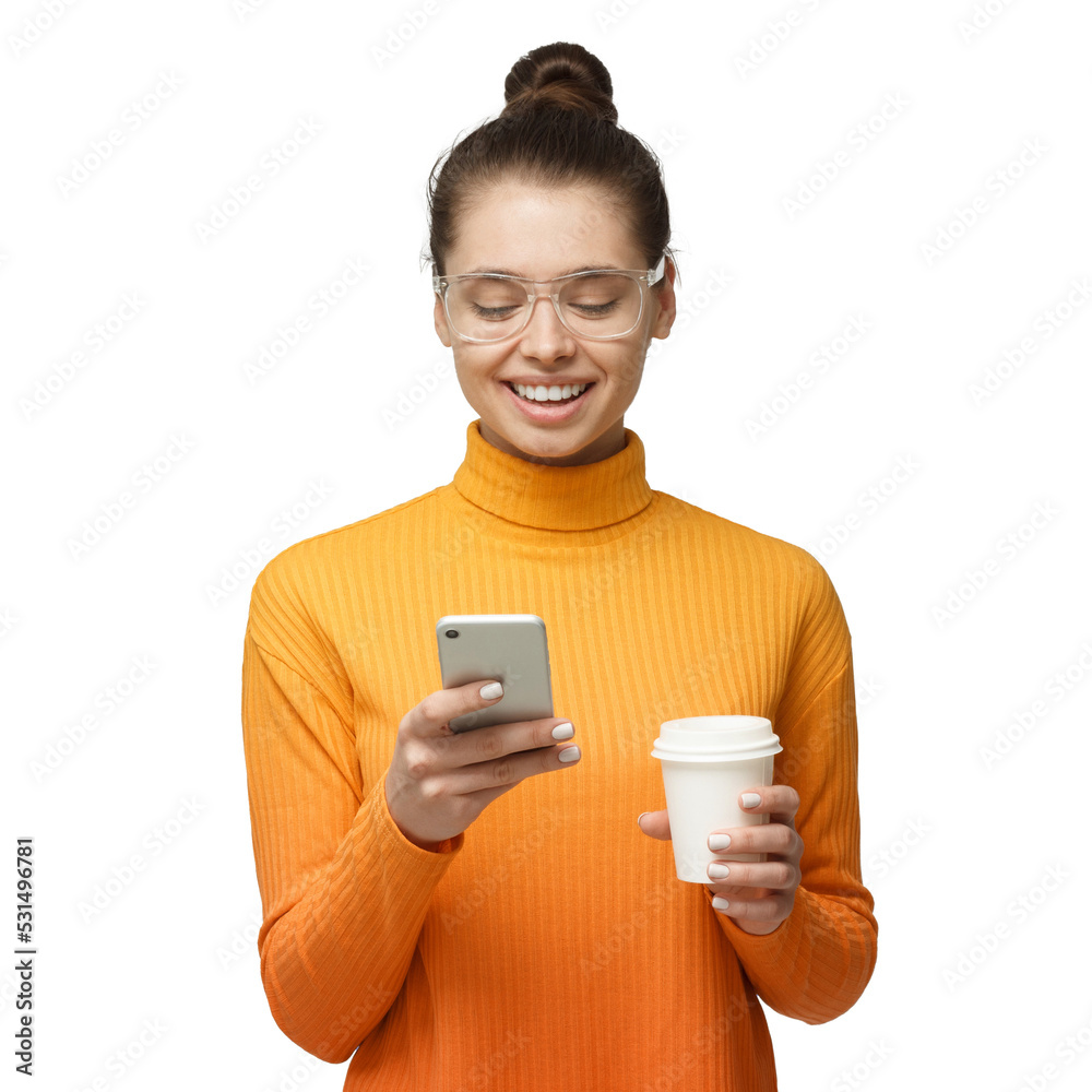 Wall mural young woman holding phone in hand, looking to screen smiling while browsing or reading message