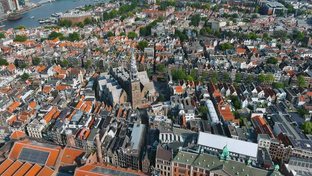 Beautiful aerial Amsterdam view from above with city central and downtown district, streets and architectures. Panoramic drone shot ft. The Oude Church and Basilica of Saint Nicholas in Netherlands 4K