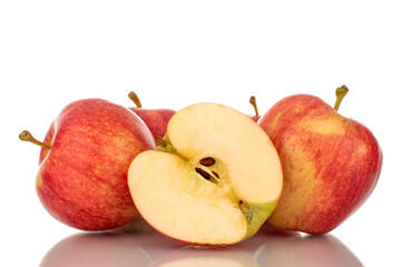 One half and four whole juicy red apples, macro, isolated on white background.