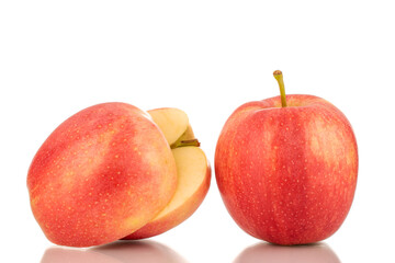 Two halves and one whole juicy red apple, macro, isolated on white background.