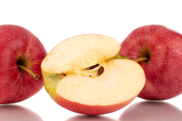 Naklejka na ściany i meble One half and two whole juicy red apples, macro, isolated on white background.