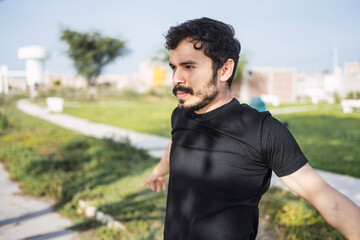 Getting ready to do his best. Portrait of a sporty young man stretching his arms while exercising outdoors.