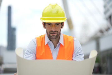 Architect or engineer with blueprints. Cauacsian Engineer checking plan on construction site. modern structure. helmet and blueprints paper.