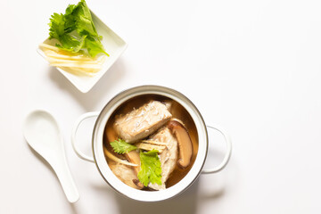 Pot of soup with sea bass fish and herb, healthy meal. Overview shot isolated on white background.