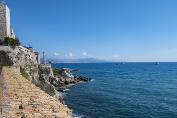 Fototapeta na wymiar Beautiful Mediterranean coastline under blue sky in Antibes - city on French Riviera between Cannes and Nice.