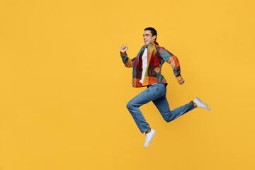 Fototapeta na wymiar Full body isde view young sporty strong middle eastern man 20s wear casual shirt white t-shirt jump high run fast hurrying isolated on plain yellow background studio portrait People lifestyle concept.