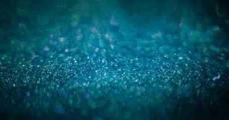 Bokeh light background. Particles flare. Color glow reflection. Defocused blue green purple sparkles reflection on dark abstract wallpaper.