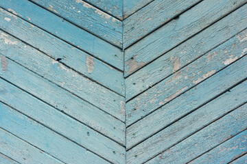 Wall of a wooden house with peeling blue paint