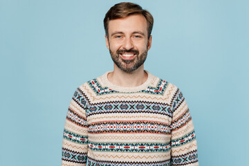 Fototapeta premium Young satisfied positive fun cool smiling happy fun cool cheerful man 30s he wearing sweater look camera isolated on plain pastel light blue cyan background studio portrait. People lifestyle concept.