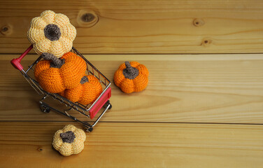 orange knitted pumpkins in a grocery cart. preparing for Halloween. autumn background for decoration. buying vegetables.
