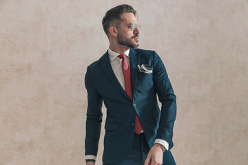 Fototapeta sexy bearded man wearing navy blue suit with red tie and handkerchief obraz