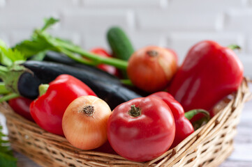 Various vegetables in a wicker basket. Close-up. Food. Tomatoes, onions, peppers, cucumbers.