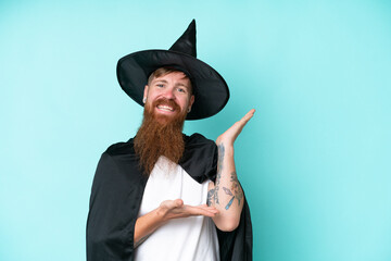 Young wizard in halloween isolated on blue background extending hands to the side for inviting to come