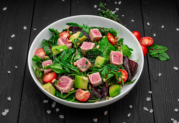 Japanese traditional salad with pieces of medium-rare grilled Ahi tuna and sesame with fresh vegetable on a bowl.