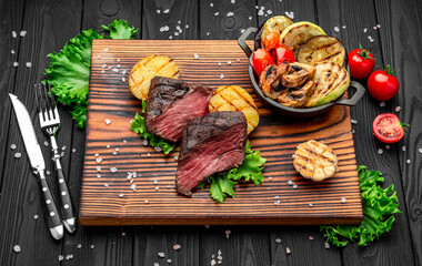 Club Beef steak with pepper sauce and Grilled vegetables on cutting board.
