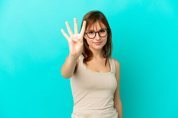 Fototapeta premium Redhead girl isolated on blue background happy and counting four with fingers