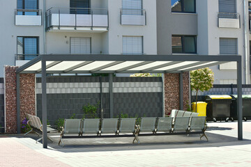 Zentraler Terrassenbereich mit Metallständer-Milchglasdach eingebauten Metallsitzen optischer...