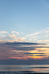 Texture sea waves at sunset with pink clouds.