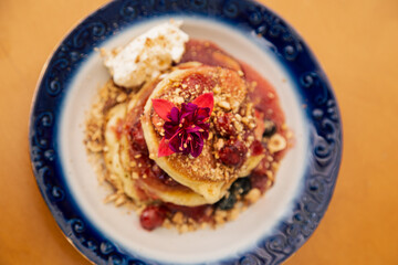 Appetizing pancakes decorated with berries and flowers.