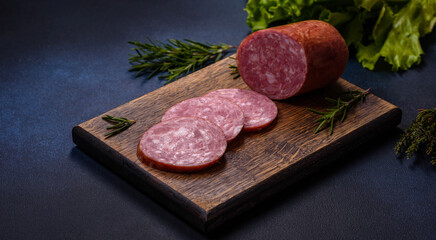 Delicious fresh smoked sausage cut with slices on a wooden cutting board
