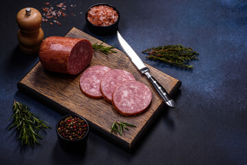 Delicious fresh smoked sausage cut with slices on a wooden cutting board