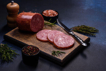 Delicious fresh smoked sausage cut with slices on a wooden cutting board