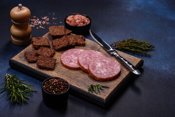Delicious fresh smoked sausage cut with slices on a wooden cutting board