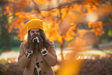 modern 40 years old woman in brown coat and yellow hat