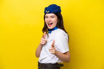 Airplane stewardess Russian woman isolated on yellow background pointing to the front and smiling