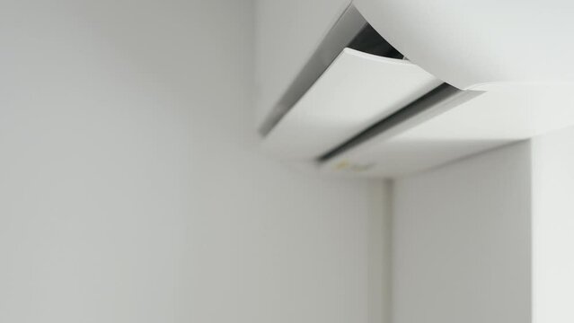 Air Conditioning Blowing Fresh Cool Air in the Office Changing the Room Temperature. Cooling Device Technology in Function. Split System. Shooting with an Air-Conditioner Working on a Hot Summer Day.