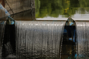 Naklejka na ściany i meble Water flowing through a sluice on a river.