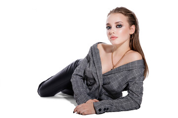 High fashion photo of a beautiful elegant young woman in a pretty gray jacket blazer, leather pants, boots on white background. Studio Shot.