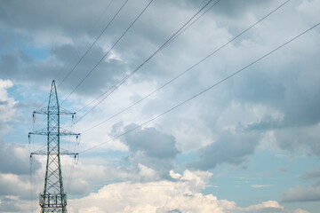 electricity transmission pylon silhouetted against blue sky at day