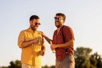 Two handsome male friends walking along the beach and hanging out talking
Summer time stock photo