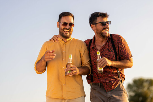 Two Handsome Male Friends Walking Along The Beach And Hanging Out Talking
Summer Time Stock Photo