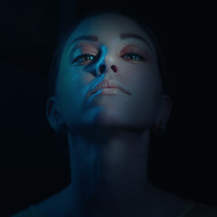 Fashion art portrait of beautiful woman face. blue light color. close up face