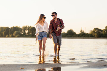 Cheerfull couple running threw water and holding hands