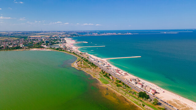 Aerial photography taken from a drone at Eforie beach with Techirghiol lake on the left side of the beach and the Black sea on the right side. A patch of land between sea and lake.
