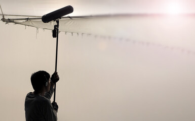 Boom Microphone for sound recording in film industry. Sound boom operator recording sound by...