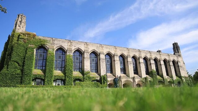 Man walking towards camera with Ivy Building in background