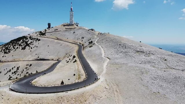 Narrow highway leading to the Mont Ventoux in France with a blue sky in the background