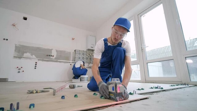 Construction, renovation, repair apartment. Installing ceramic floor tiles - measuring and cutting the pieces. Cuts tile. Tile cutting