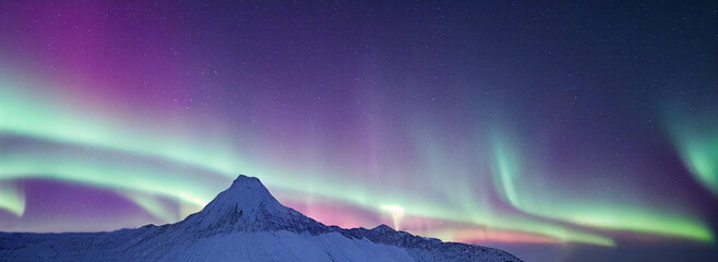 Northern Lights over snowy mountains. Aurora borealis with starry in the night sky. Fantastic Winter Epic Magical Landscape of Mountains	