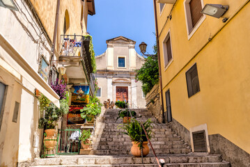 Fototapeta na wymiar Taormina, Italy - July 22, 2022: Scenic streets and sidewalks in Taormina, Sicily 