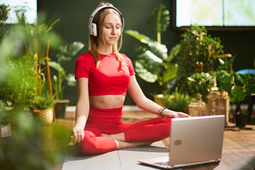 young female with laptop having webcam meeting and meditating