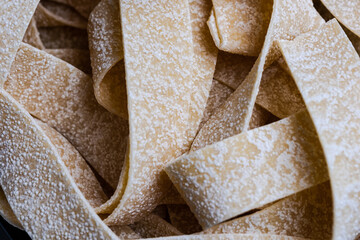 pile of uncooked raw Italian pasta, yellow background, food background, place for your text 