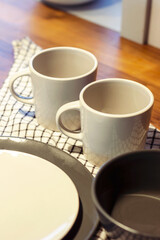 Clean dishes are on a kitchen towel. Cups and plates for food are ready for eating