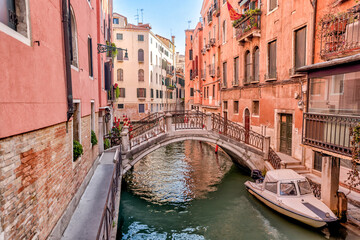 Fototapeta na wymiar Venice, Italy - July 5, 2022: Building exteriors, boats and gondolas along the canals in Venice Italy 