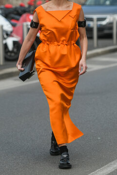 Street Style, Woman Wearing Orange Prada Long Dress, Prada Black Bag, Prada Loafers.